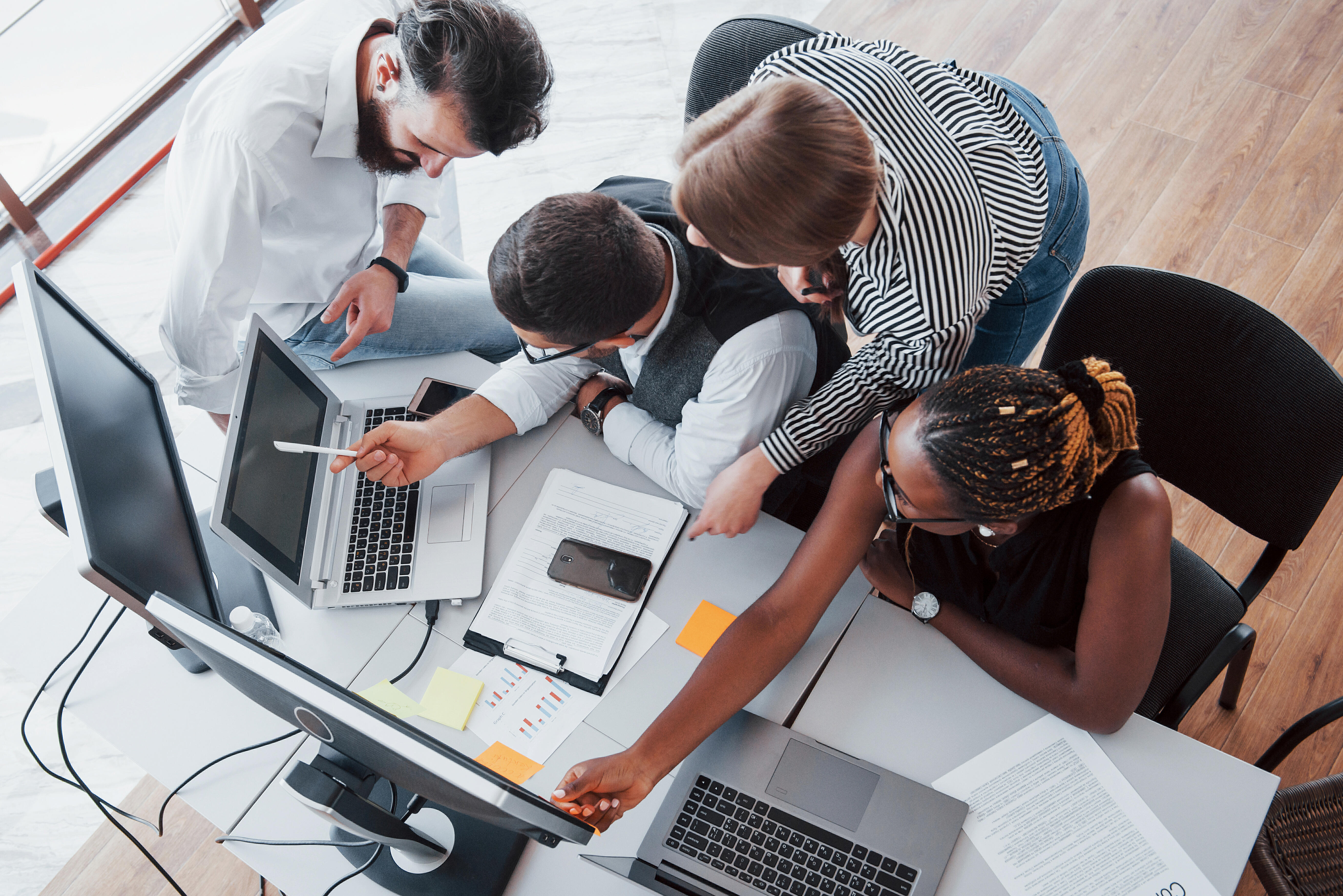 Groupe de collègues en réunion de travail autour d'un bureau