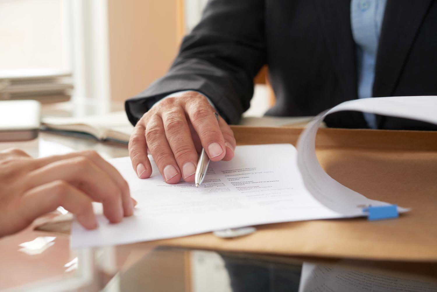 Deux mains apparentes désignant des documents